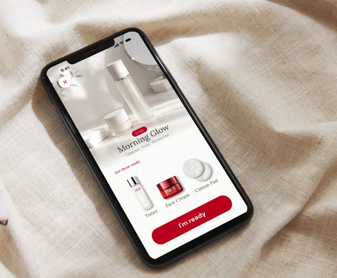 A phone resting on linen, showing a Morning Glow routine screen.